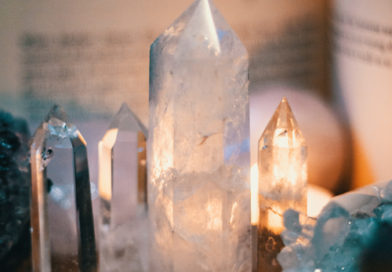 polished crystals sitting on a slab of wood with light reflecting from behind. Are you wanting to expand your tools for witchcraft? These must-have crystals for witches may be just what you are looking for!